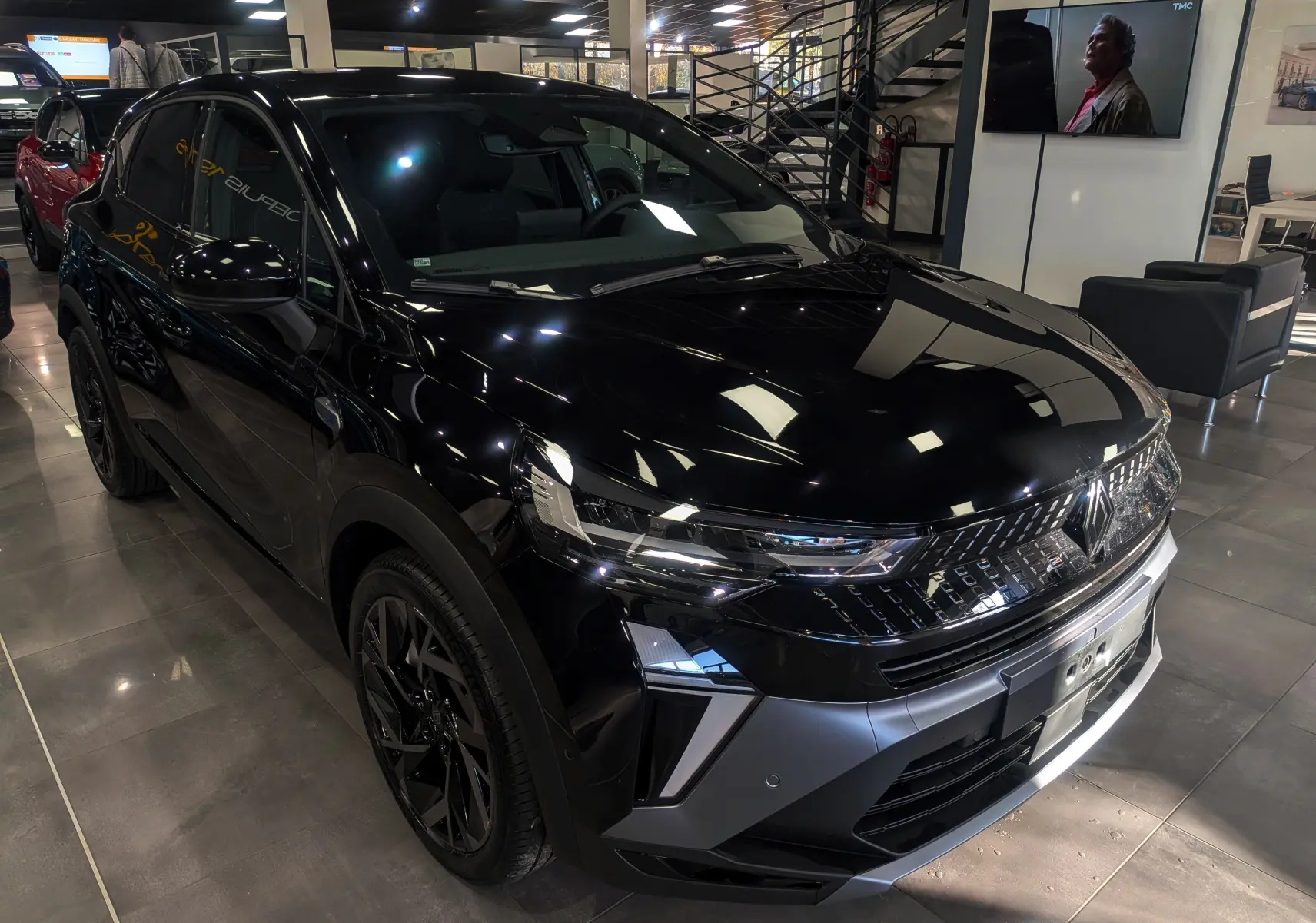 Renault Captur E-Tech Full Hybrid noir étoilé vu en 3/4 avant droit dans un showroom moderne.