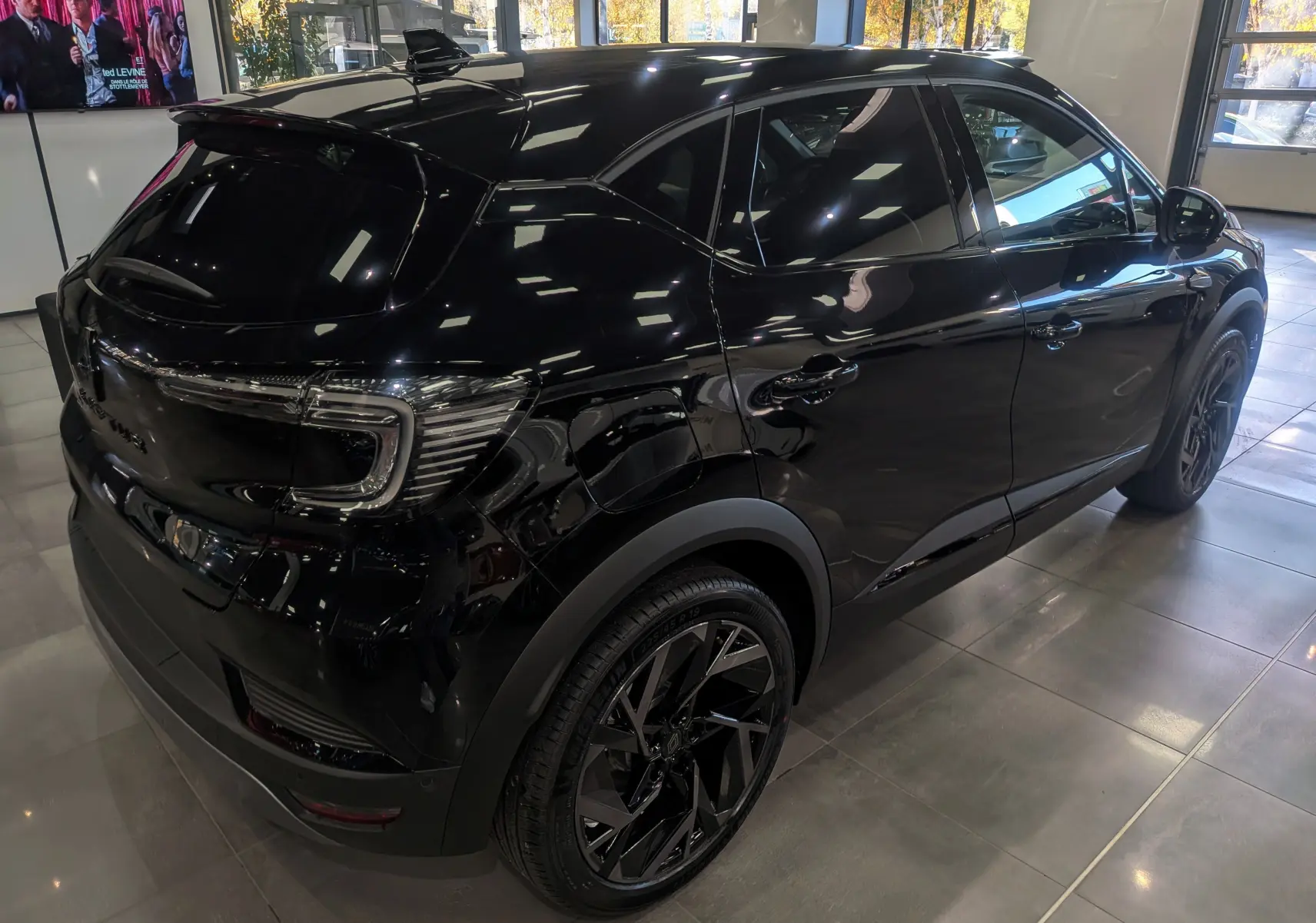 Vue 3/4 arrière droite du Renault Captur E-TECH Full Hybrid 160 CH esprit Alpine noir étoilé, en showroom lumineux.