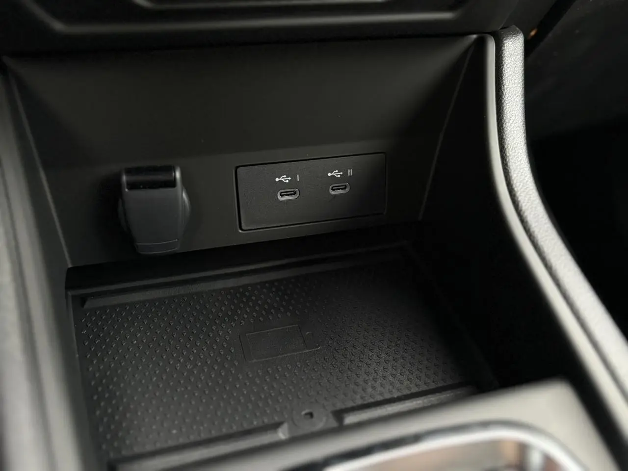 Prise USB double et prise 12V dans la console centrale noire du Renault Captur Bleu Iron 2025.