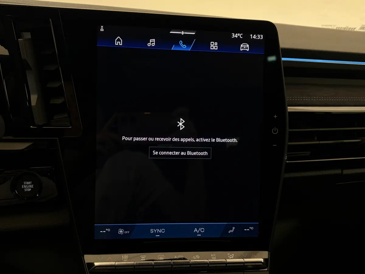 Écran tactile central du tableau de bord du Renault Espace blanc, affichant la connexion Bluetooth, intérieur moderne noir.