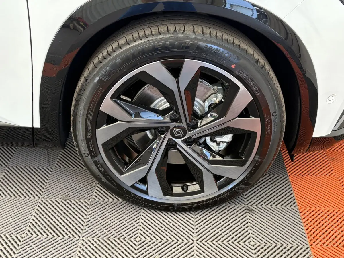 Gros plan sur la roue avant droite du Renault Espace blanc, jante alliage noire et argentée au design moderne.