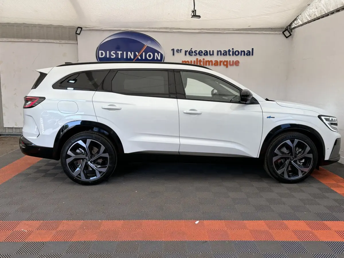 Vue latérale droite d'un Renault Espace blanc esprit Alpine 7 places avec jantes noires et vitres teintées.