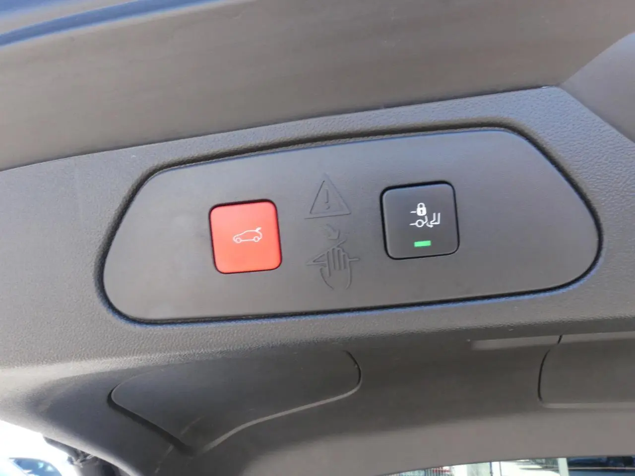 Gros plan sur les boutons du hayon motorisé mains-libres du toit intérieur d’un Opel Grandland blanc métallisé 2024.