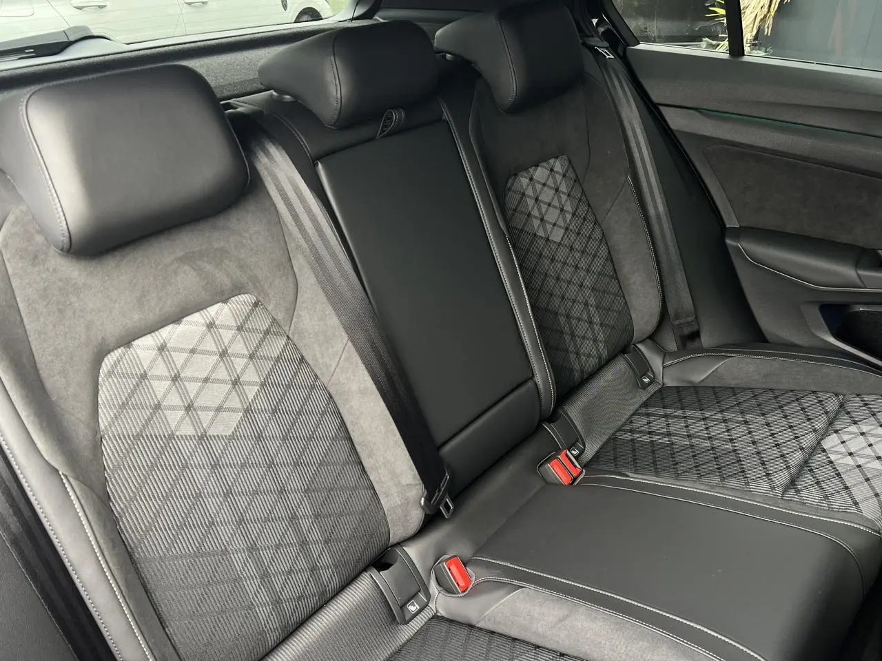 Vue intérieure des sièges arrière en tissu et cuir noir avec motifs géométriques de la Volkswagen Golf VIII R-Line.