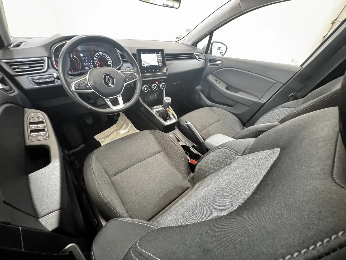 Vue intérieure côté conducteur de la Renault Clio Business TCe 100 2020, sièges tissu gris et tableau de bord avec écran tactile.