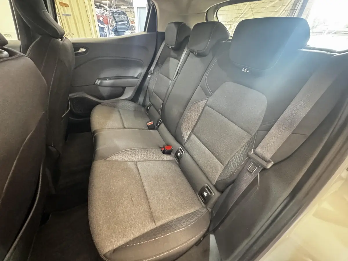Vue intérieure côté droit sur la banquette arrière grise de la Renault Clio Business TCe 100 avec ceintures et appuie-têtes.