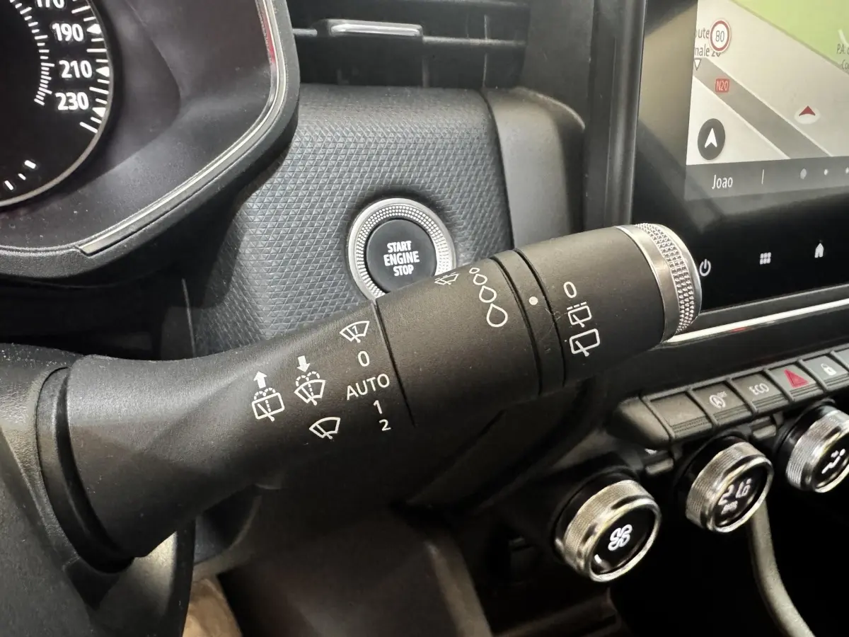 Gros plan sur la commande d’essuie-glace et le bouton start/stop dans l’habitacle de la Renault Clio Business gris clair 2020.