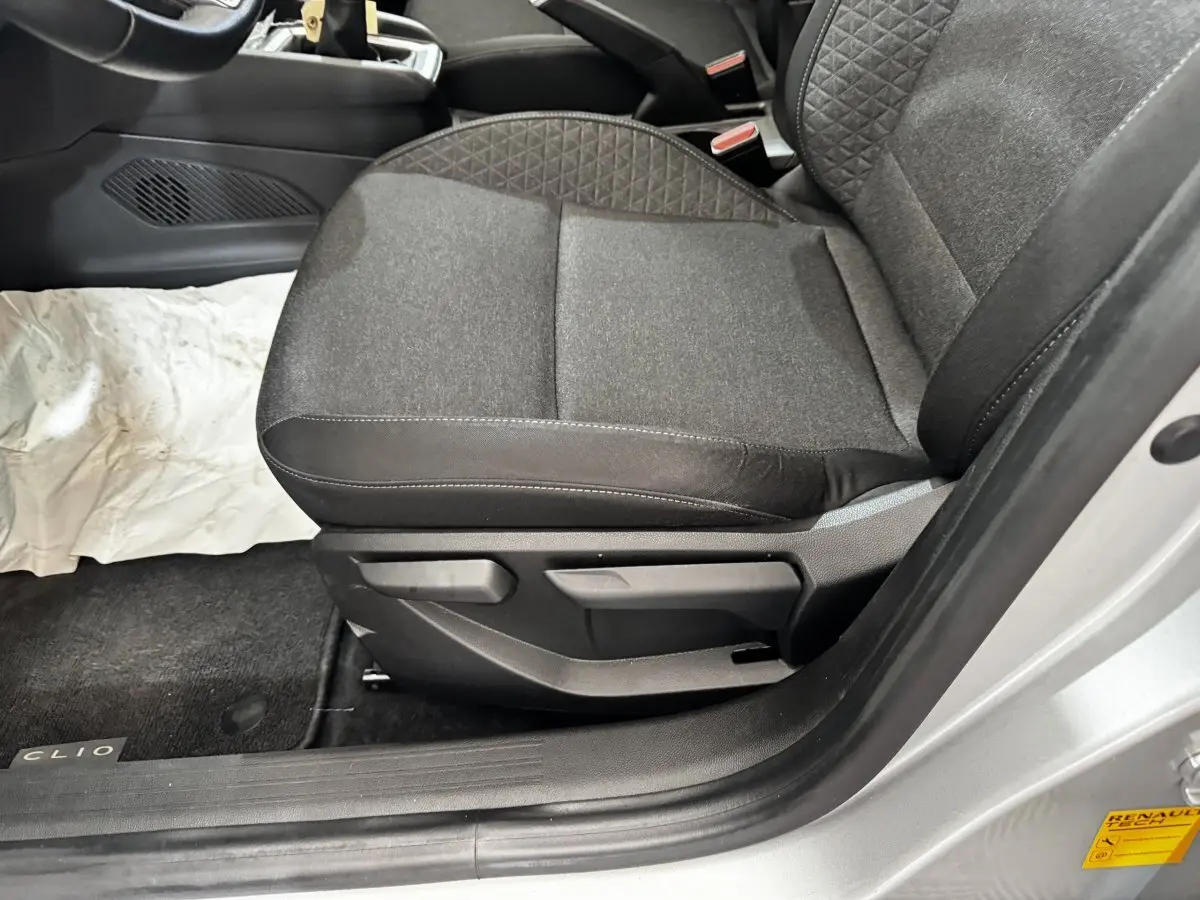 Vue rapprochée du siège avant droit gris foncé de la Renault Clio Business TCe 100, avec porte ouverte côté droit.