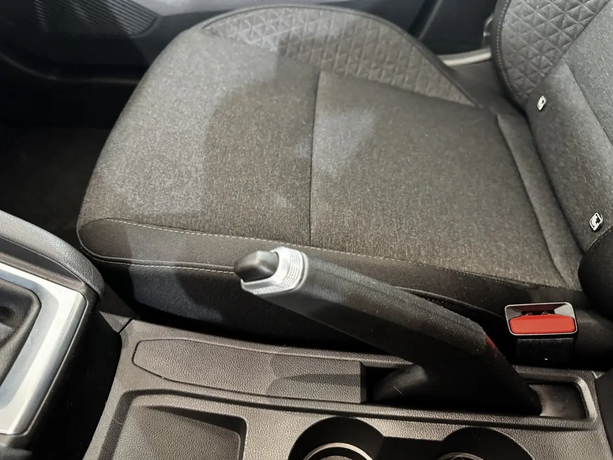 Gros plan sur le frein à main et la console centrale, siège tissu gris foncé de la Renault Clio Business TCe 100 2020.