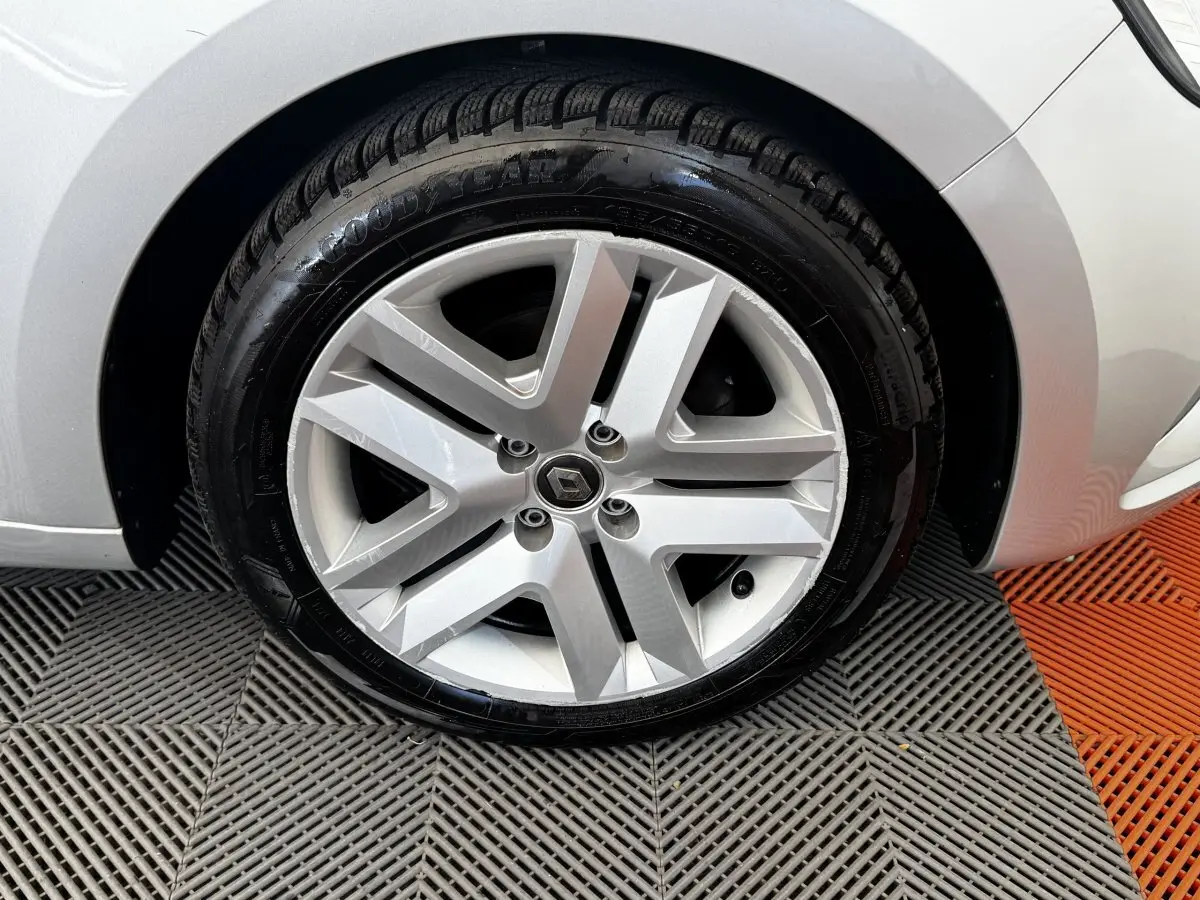 Gros plan sur la roue avant droite gris clair d'une Renault Clio Business TCe 100 avec jante alliage à cinq branches.