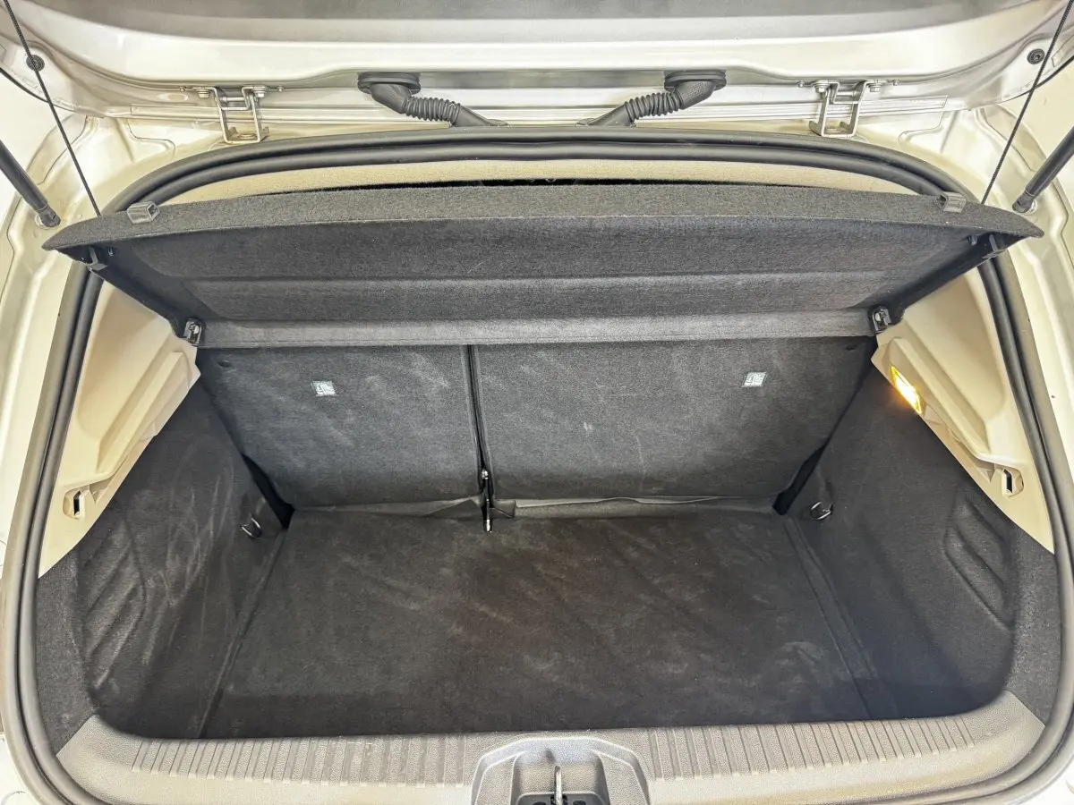 Coffre ouvert de Renault Clio Business gris clair, vue arrière montrant l'espace de chargement vide et la tablette cache-bagages.