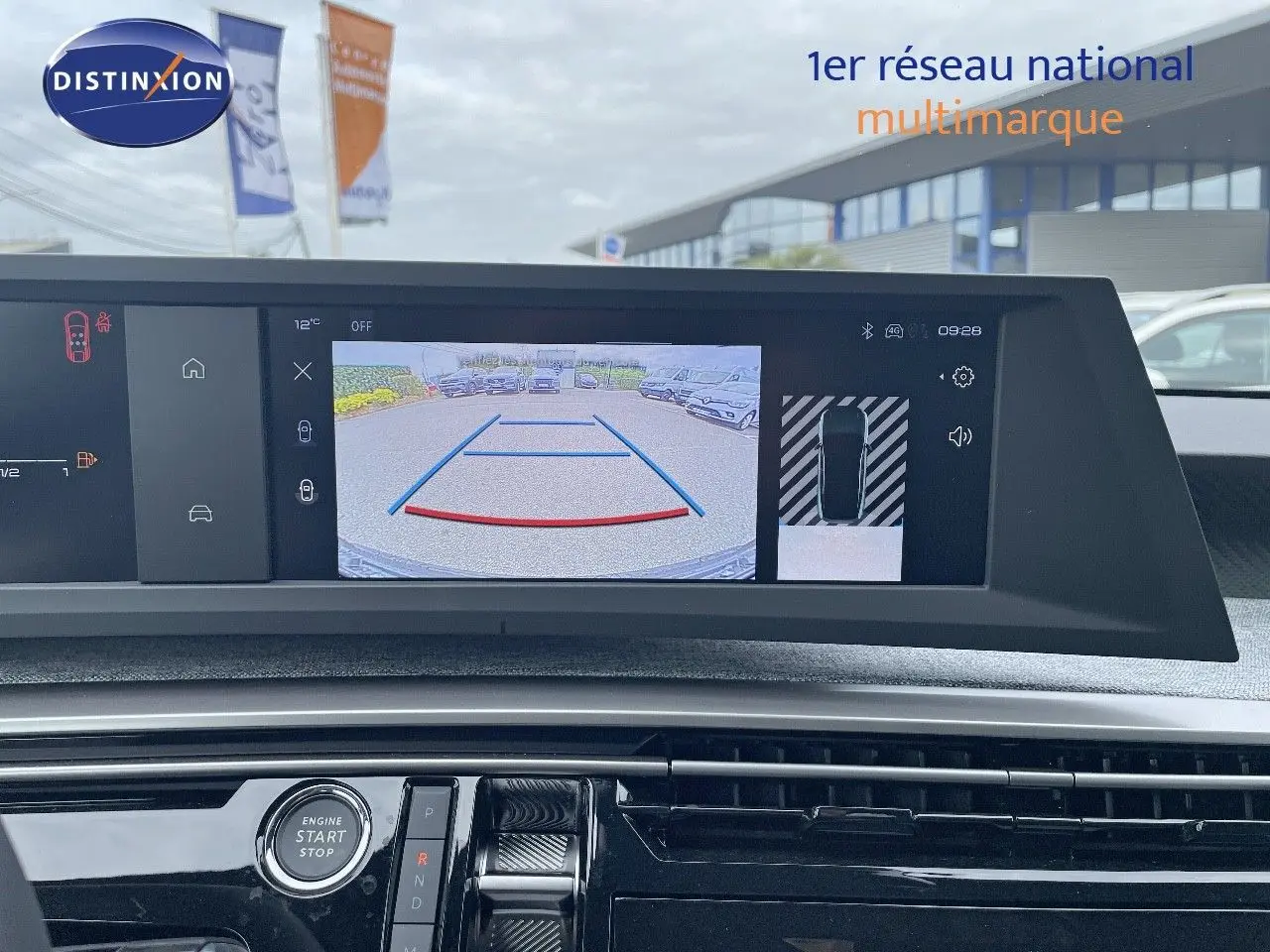 Vue intérieure du tableau de bord du Peugeot 3008 Hybrid 2025, écran de caméra de recul affiché en plein jour.