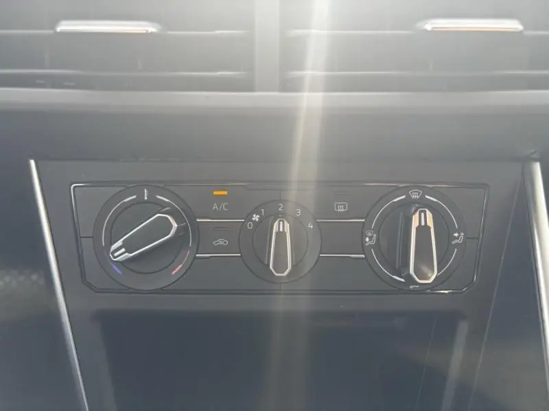 Gros plan sur les commandes de climatisation manuelle du Volkswagen Taigo 2025 en Reflet d'Argent métallisé.