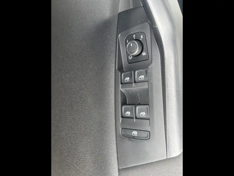 Panneau de commandes des vitres et réglage des rétroviseurs côté conducteur intérieur noir du Volkswagen Taigo 2025.