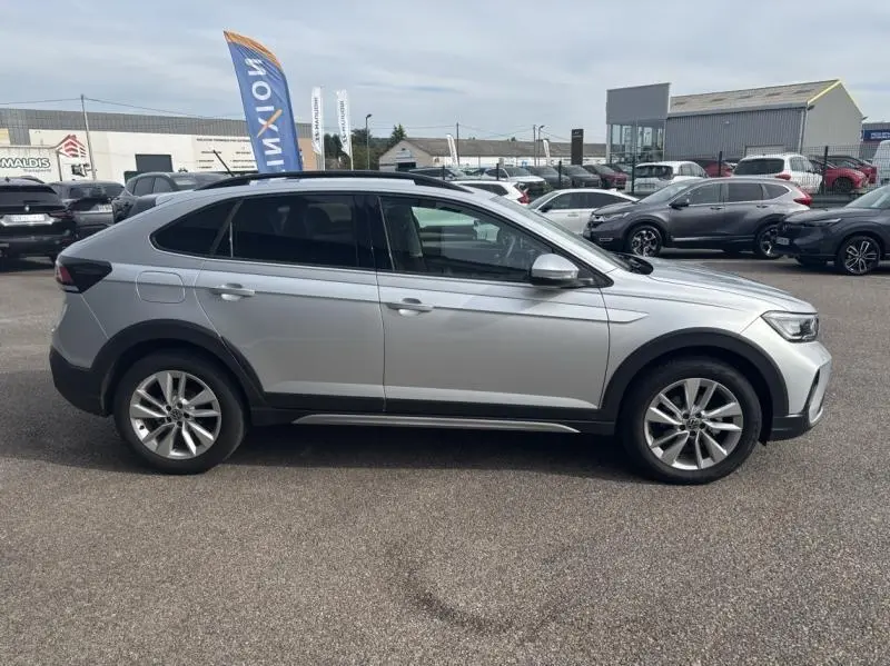 Profil côté gauche du Volkswagen Taigo 2025 en Reflet d'Argent métallisé avec jantes alliage et vitres surteintées.