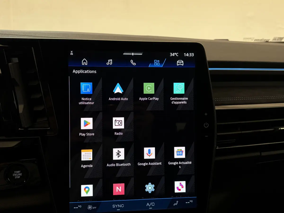 Écran tactile central affichant les applications multimédia dans l’habitacle d’un Renault Espace blanc, vue intérieure frontale.