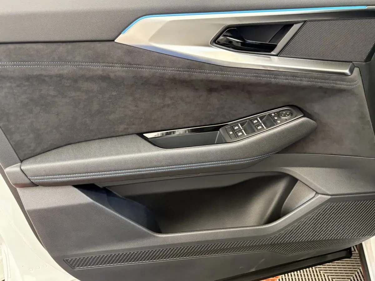 Gros plan sur la porte avant gauche blanche du Renault Espace 2025, avec garniture noire et commandes de vitres.