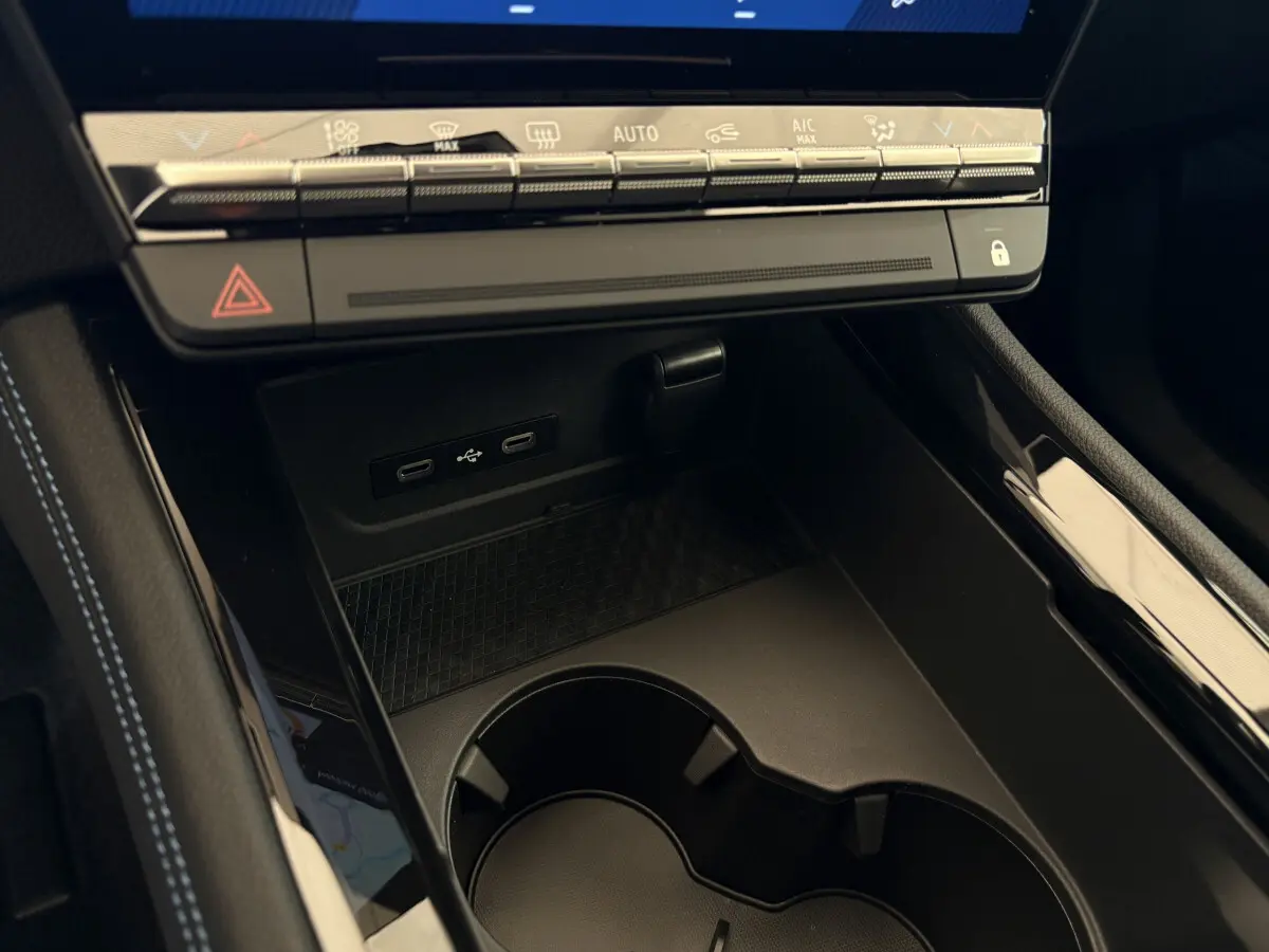 Gros plan sur la console centrale noire du Renault Espace 2025, avec ports USB-C et commandes climatisation tactiles.