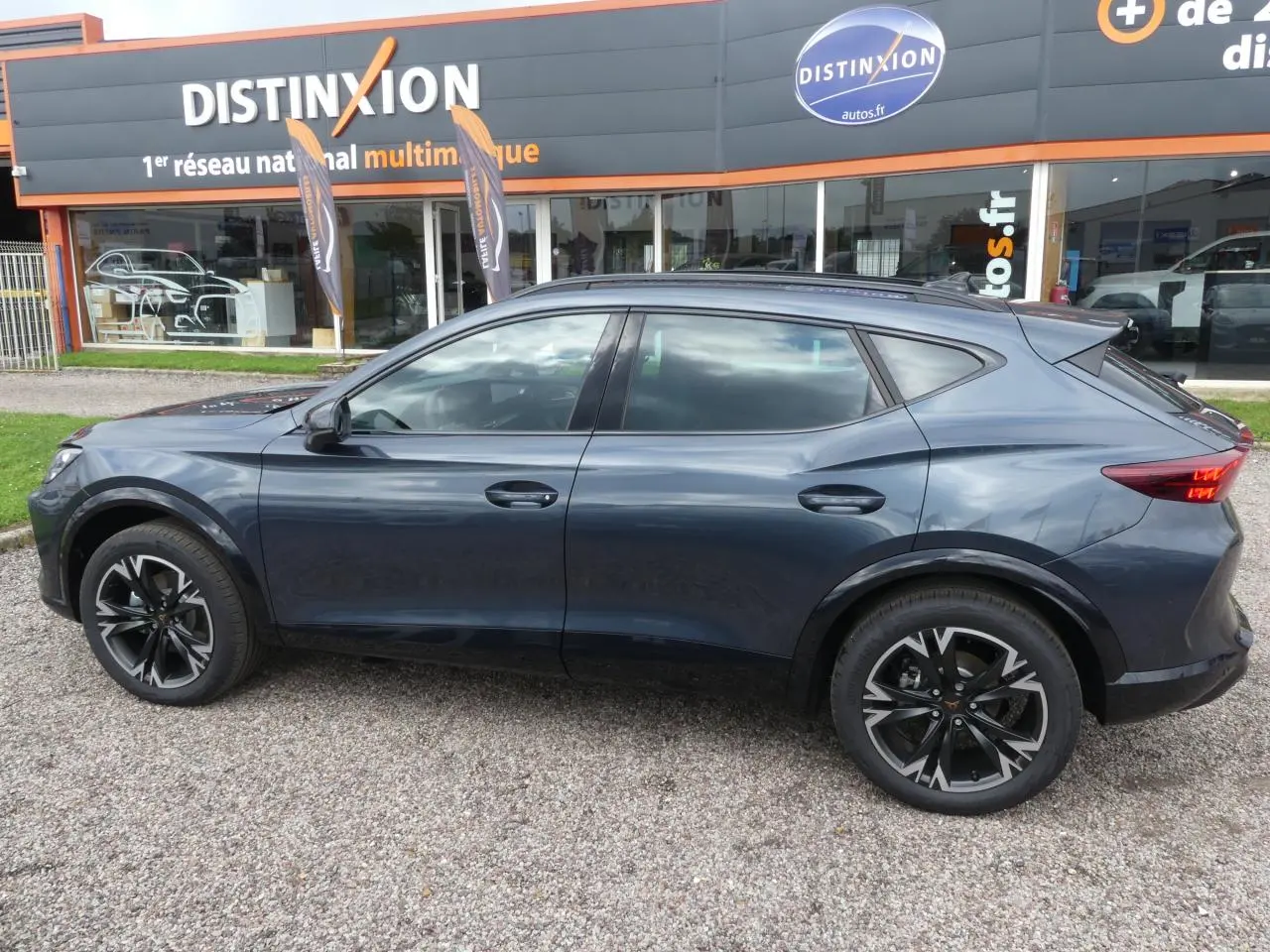 Profil droit du CUPRA Formentor gris magnétique 2025 avec jantes alliage noires et toit panoramique visible.