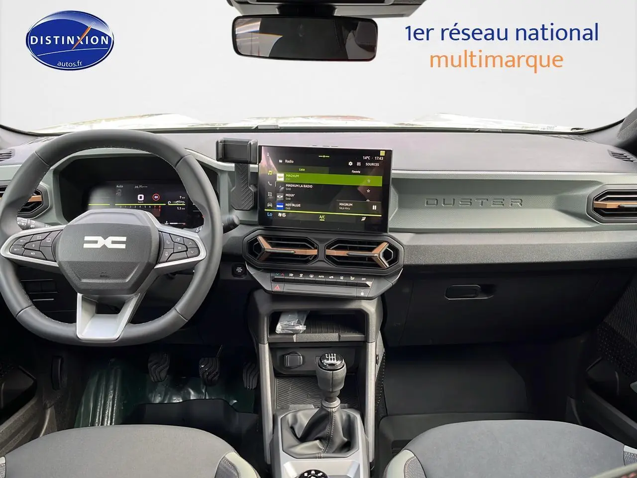 Intérieur moderne du Dacia Duster 2025, vue frontale sur tableau de bord gris avec écran tactile et boîte manuelle.