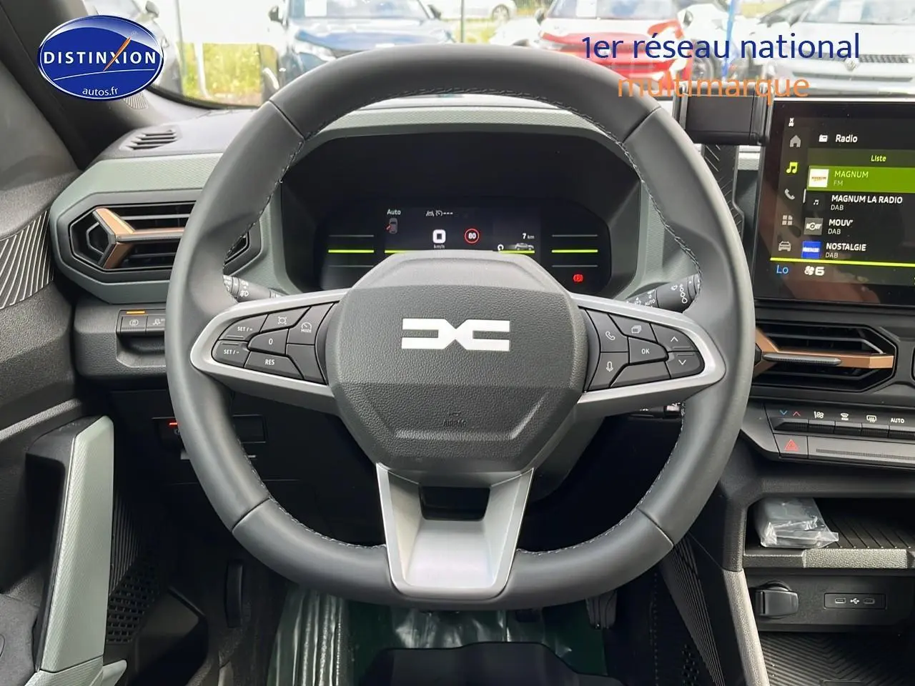 Vue frontale du volant multifonction et du tableau de bord numérique du Dacia Duster 2025 couleur Sandstone.