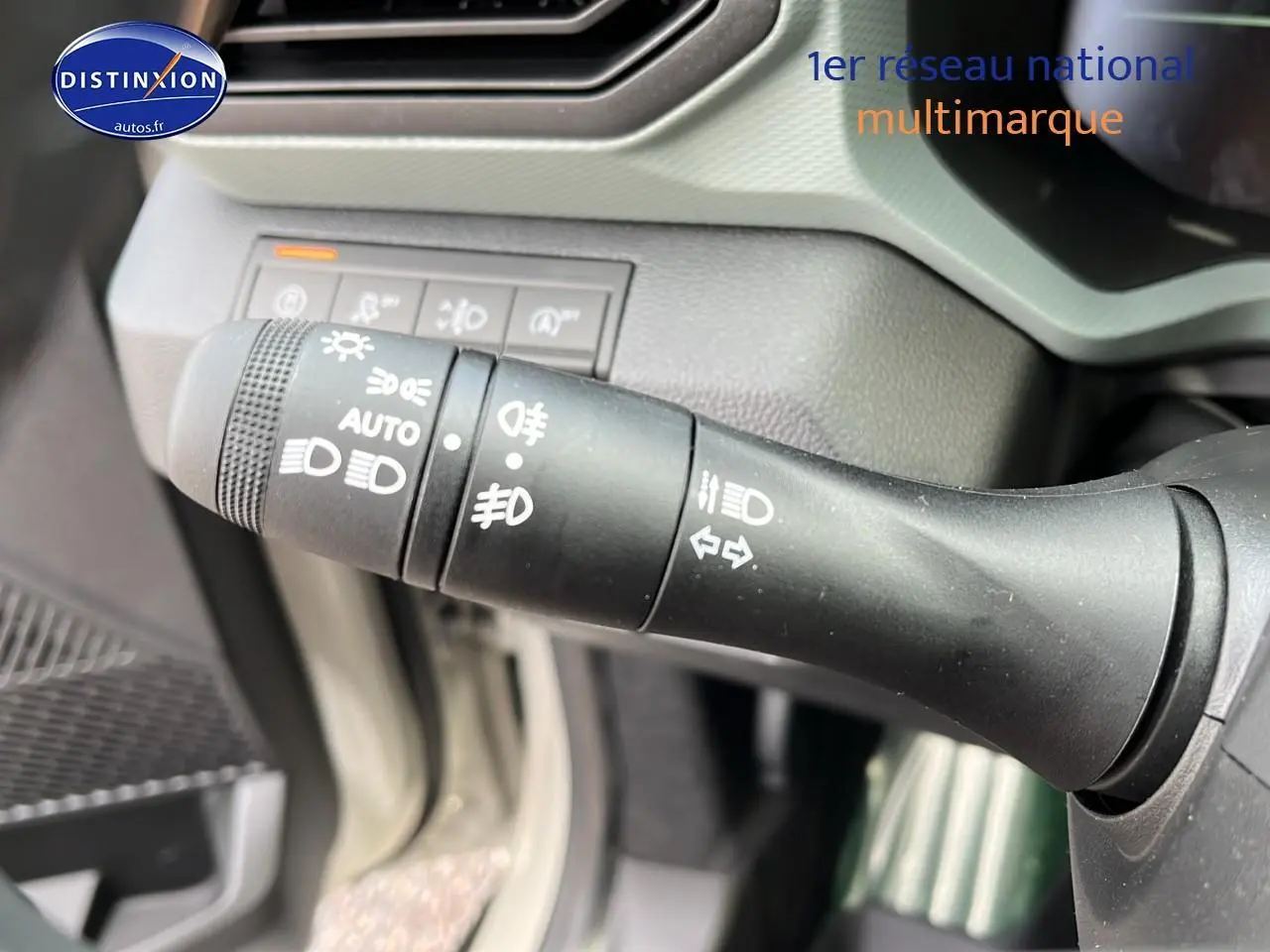 Gros plan sur la commande des feux et clignotants du Dacia Duster 2025, intérieur noir et gris.
