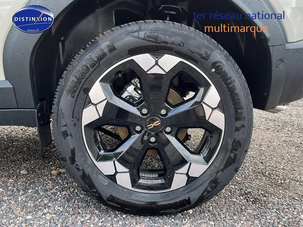 Gros plan sur la jante alu noire et argent du Dacia Duster 2025 couleur Sandstone côté avant droit.