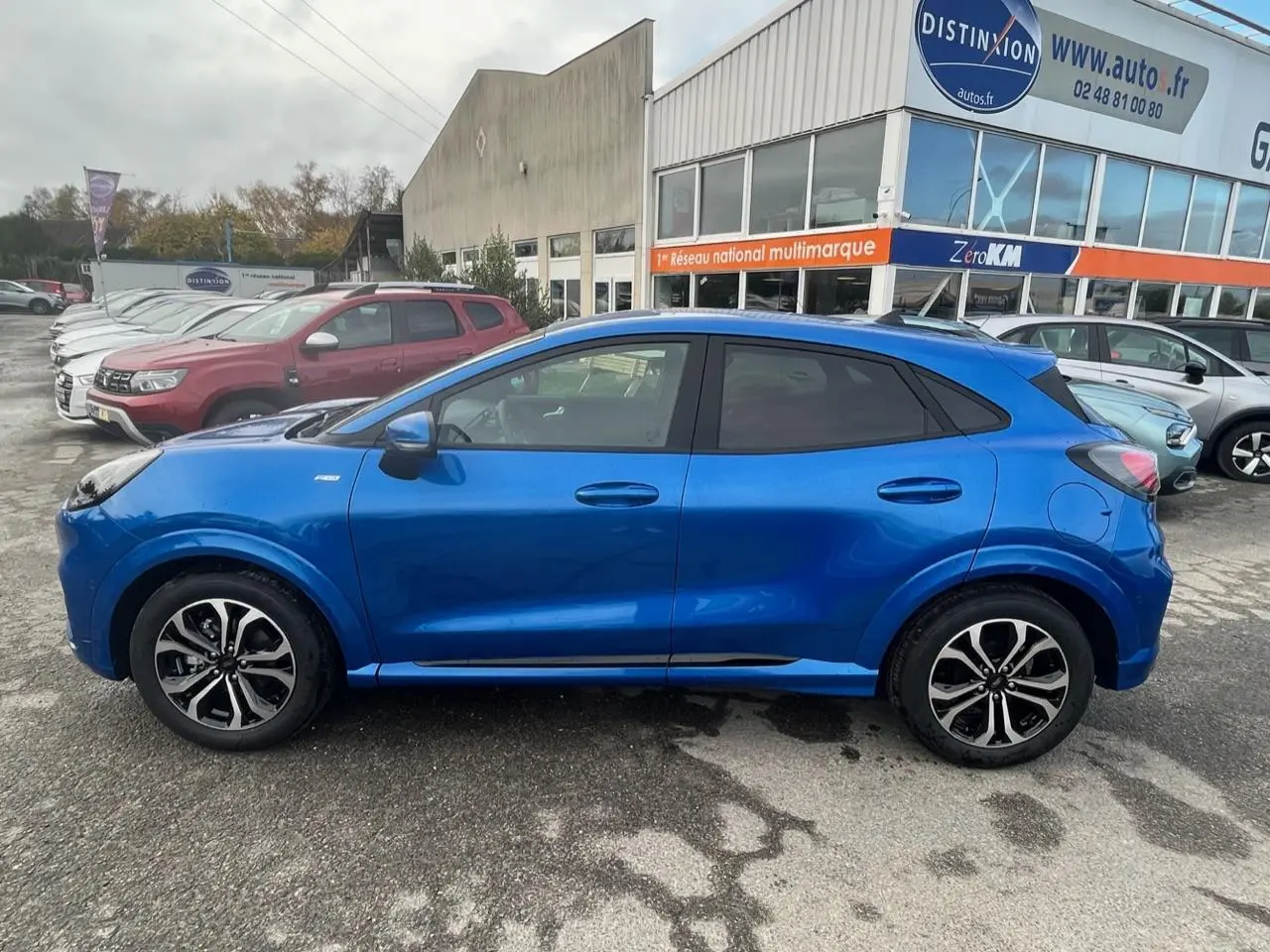 Profil côté gauche du Ford Puma bleu métallisé 2022 avec jantes alliage noires et badges ST-Line visibles.