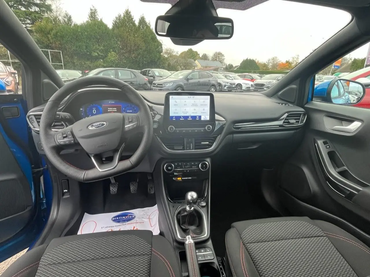Intérieur du Ford Puma bleu 2022, vue avant centrée sur le tableau de bord et la boîte manuelle.