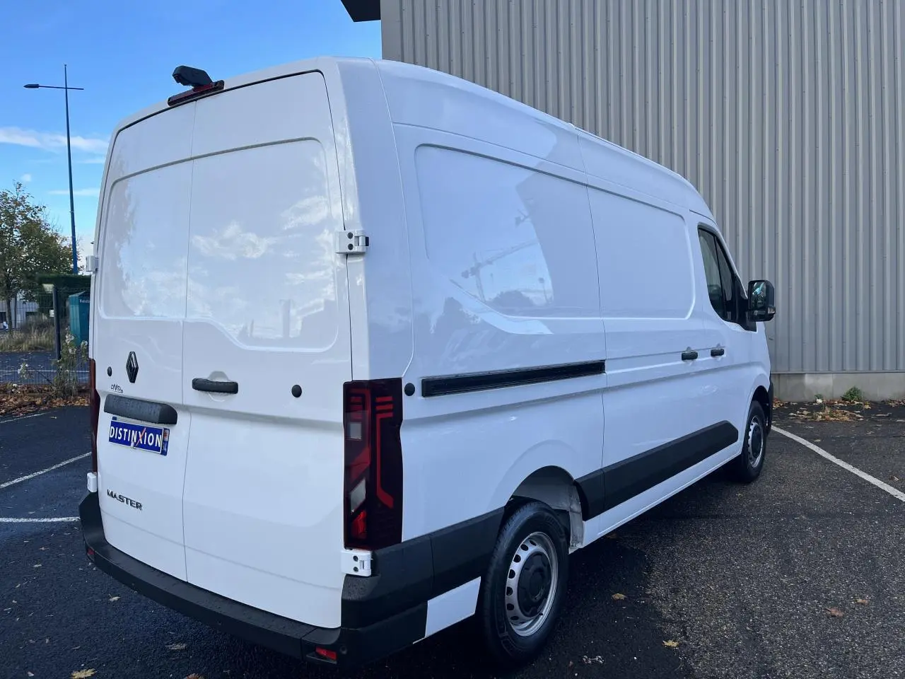 Vue 3/4 arrière droite du Renault Master blanc, fourgon tôlé avec feux arrière verticaux et jantes tôle.