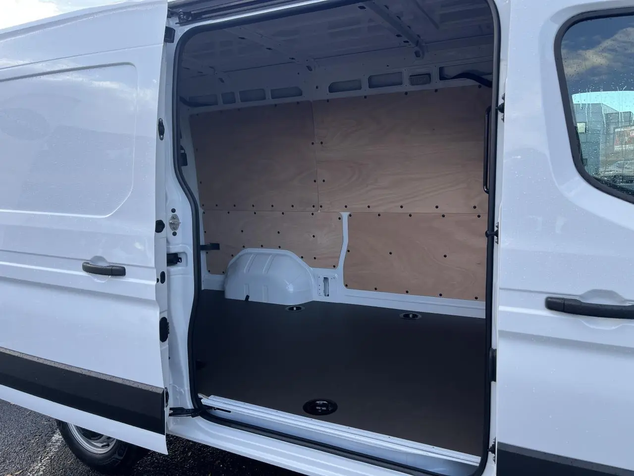 Vue latérale droite du Renault Master blanc 2025 avec porte coulissante ouverte montrant l'intérieur aménagé en fourgon.