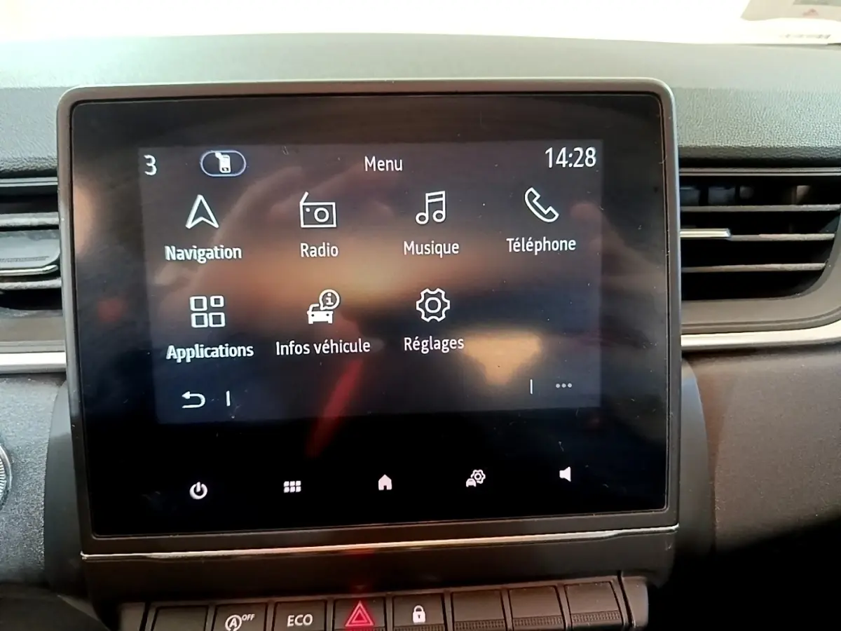 Écran tactile central du tableau de bord du Renault Captur Business noir, affichant le menu principal avec navigation et radio.