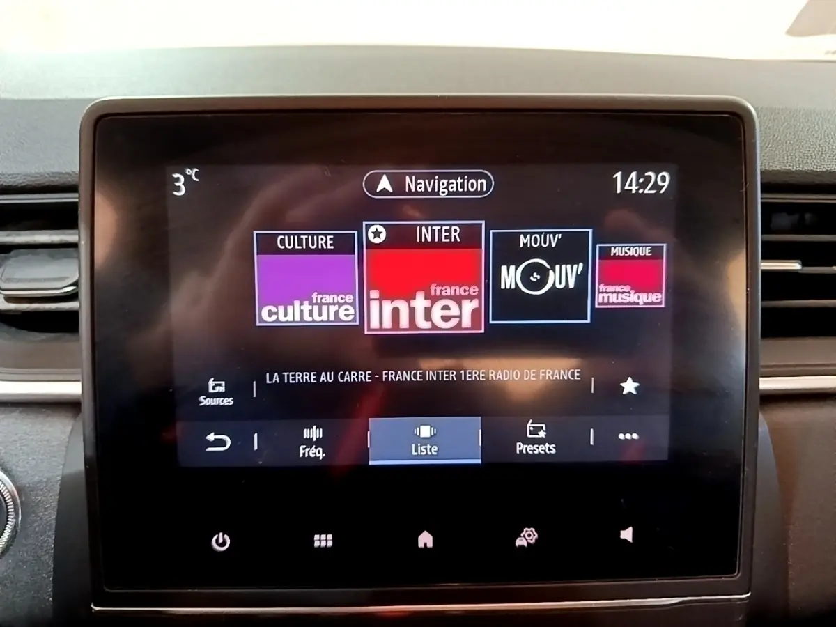 Écran tactile central du tableau de bord du Renault Captur Business noir, affichant les radios et la navigation.