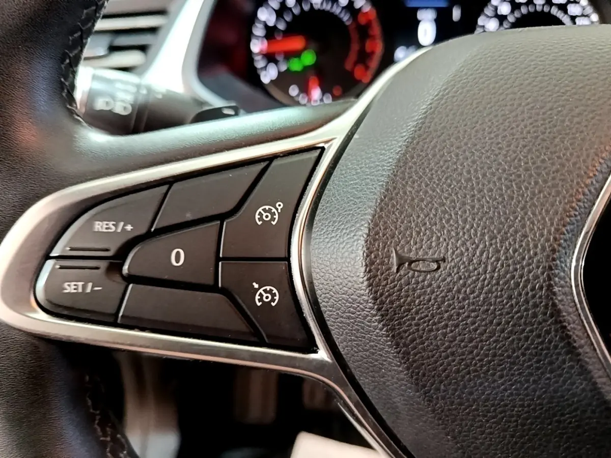 Gros plan sur le côté gauche du volant noir du Renault Captur 2021 avec commandes du régulateur de vitesse.