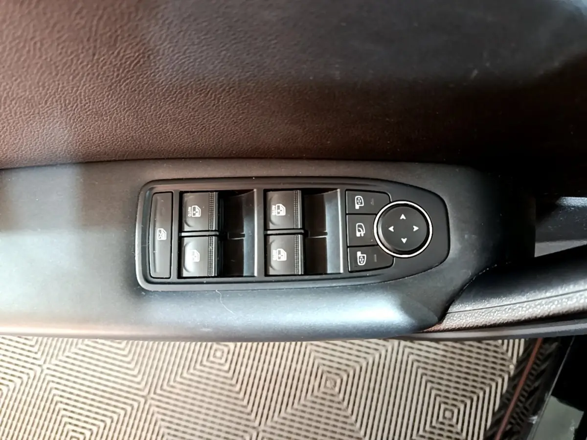 Gros plan sur les commandes des vitres électriques et rétroviseurs du côté conducteur du Renault Captur Business noir 2021.