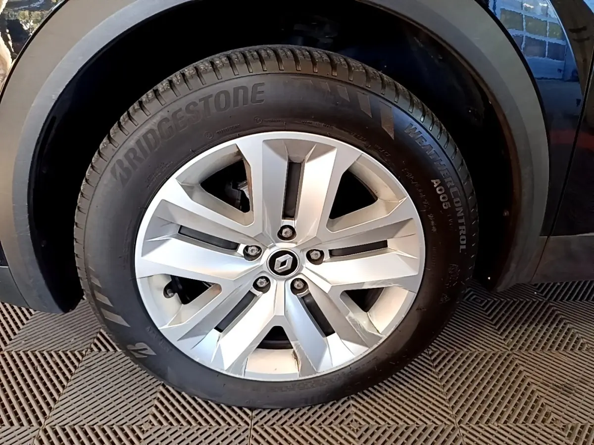 Gros plan sur la roue arrière droite du Renault Captur noir 2021, soulignant l'archivolte et le pneu visible.