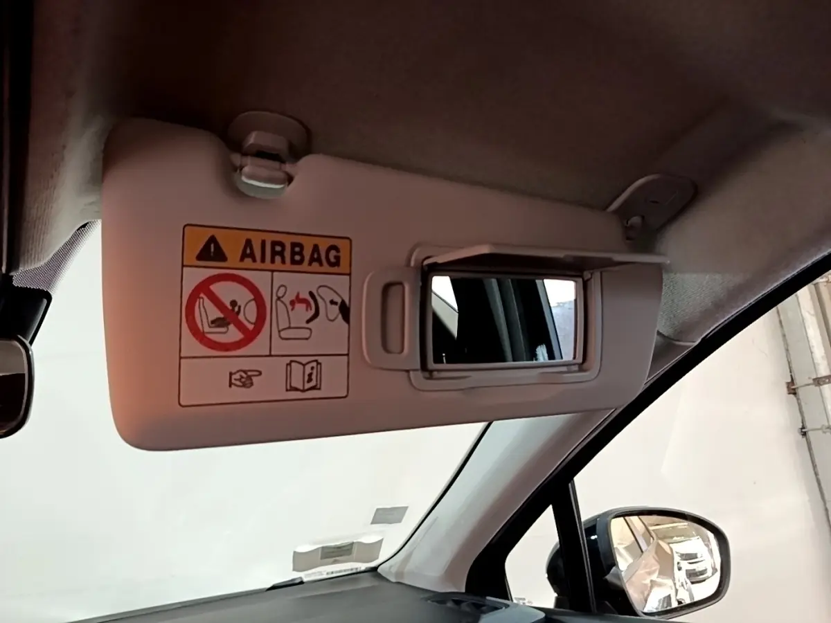 Détail intérieur du pare-soleil côté conducteur avec miroir et avertissement airbag dans un Renault Captur noir 2021.