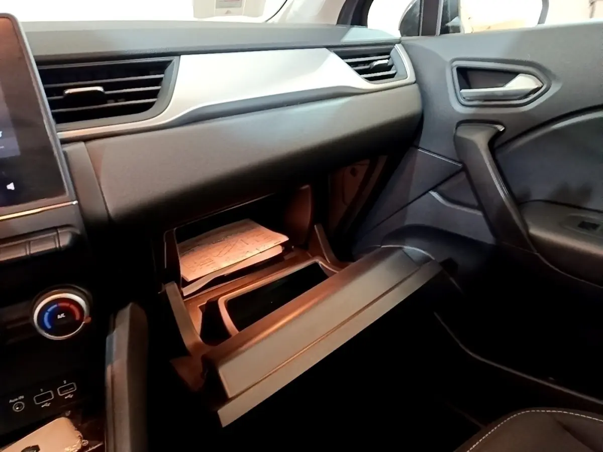 Intérieur Renault Captur Business 2021, vue côté passager sur boîte à gants ouverte et tableau de bord noir.