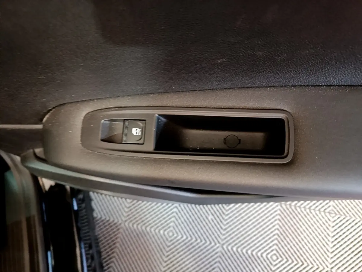 Détail de la commande de verrouillage centralisé sur la porte intérieure côté gauche du Renault Captur noir Business 2021.