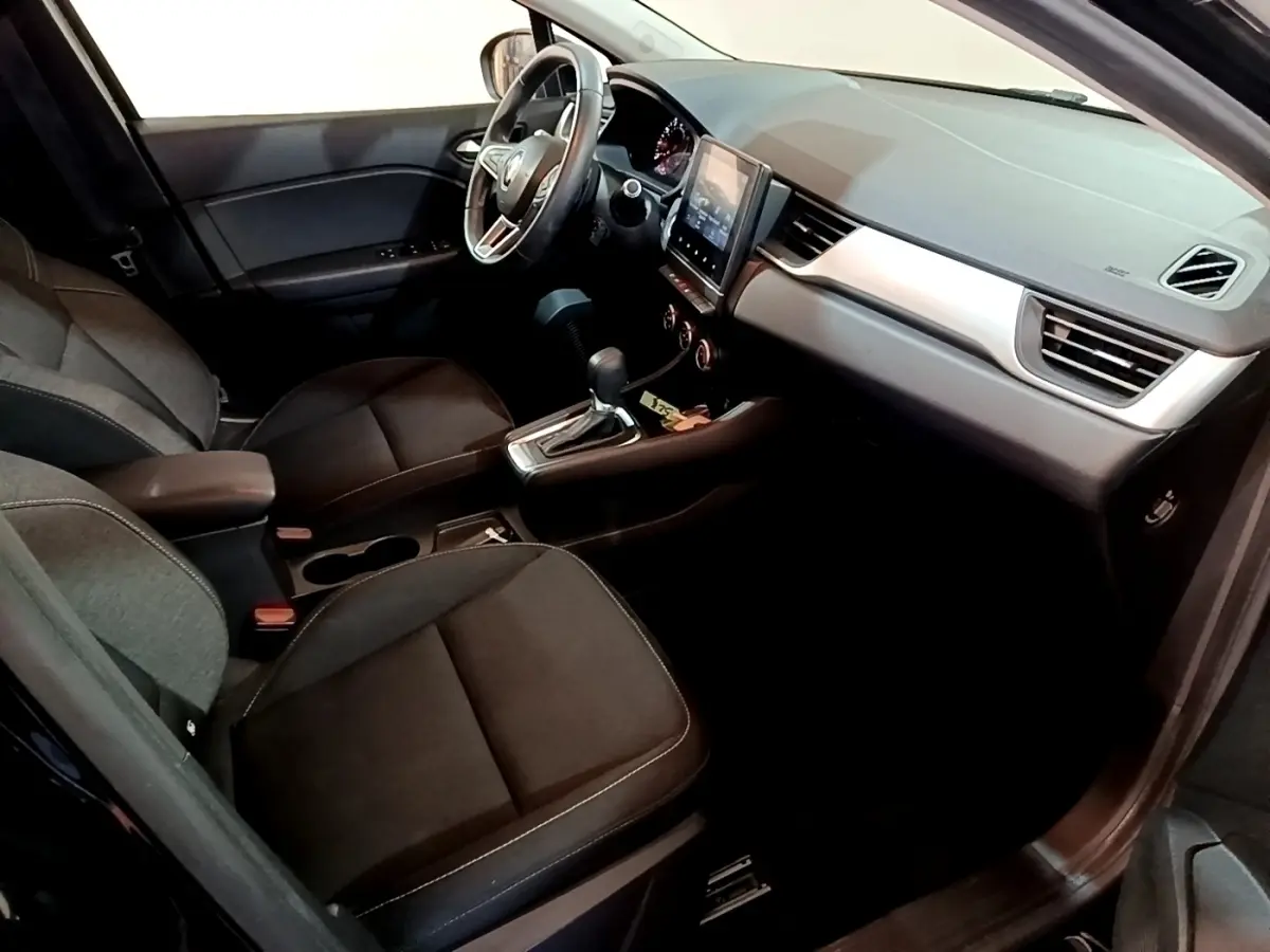 Vue intérieure côté conducteur du Renault Captur Business 2021, sièges noirs et écran tactile central visible.