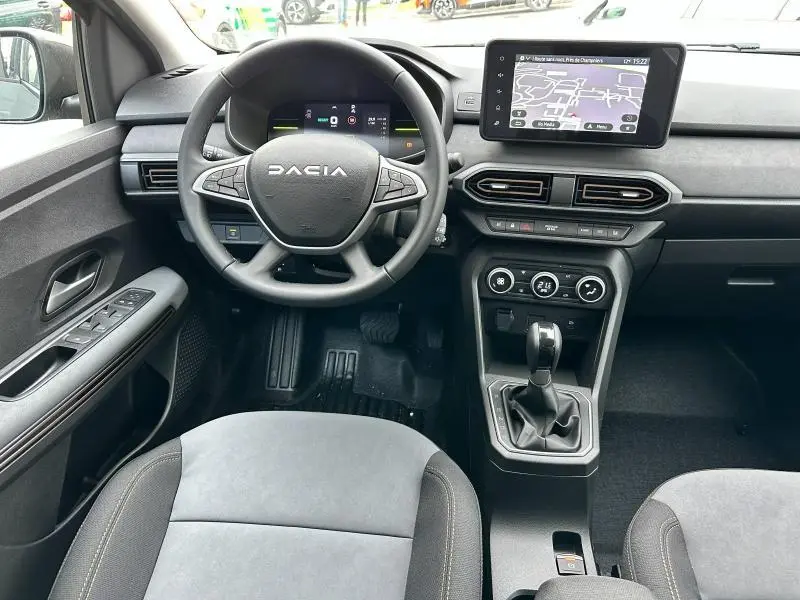 Vue intérieure avant du tableau de bord et volant du Dacia Jogger 1.6 hybrid 2025 avec écran tactile et commandes au volant.