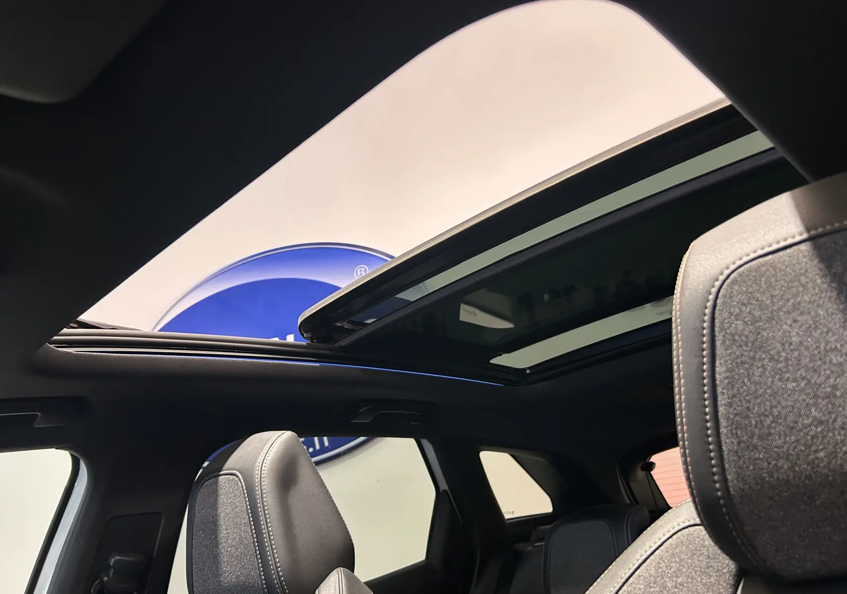 Vue intérieure du toit ouvrant panoramique et des sièges avant gris du Peugeot 3008 blanc, version GT Line 2020.