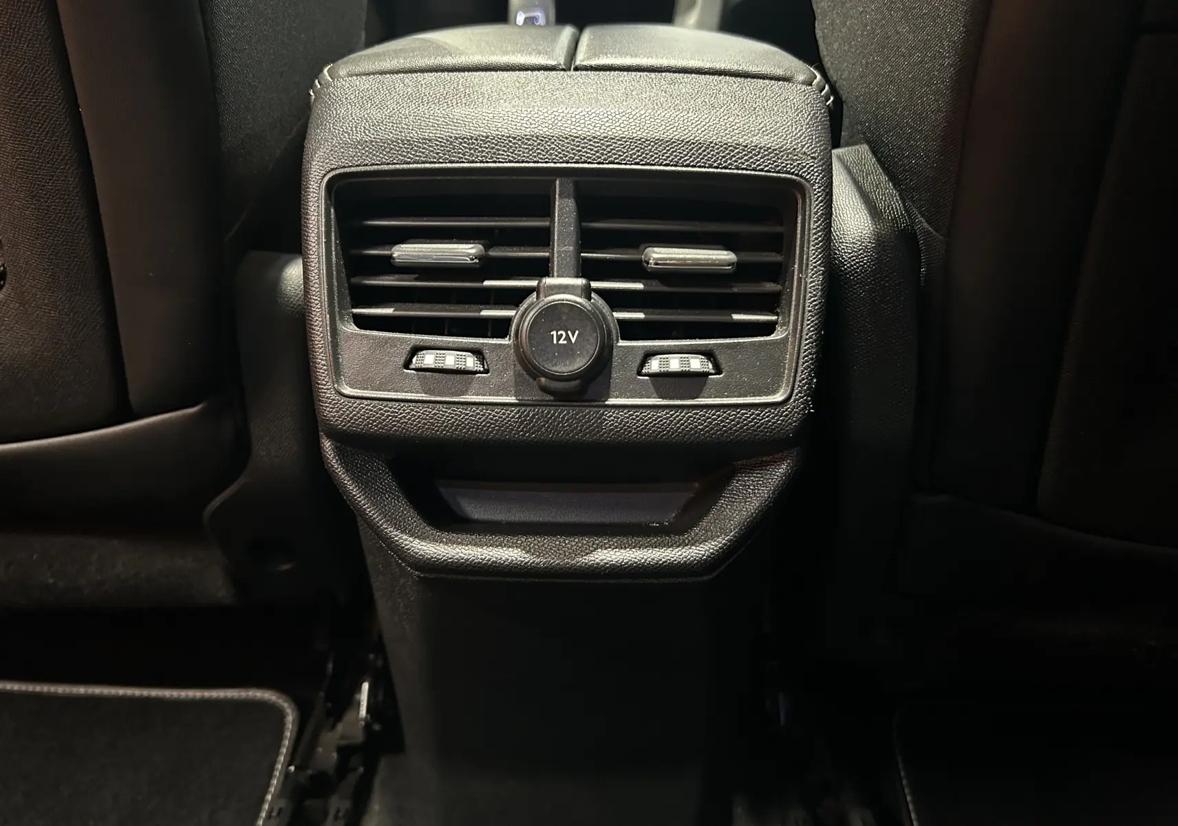 Vue rapprochée des aérateurs arrière et prise 12V du Peugeot 3008 GT Line 2020, intérieur noir.