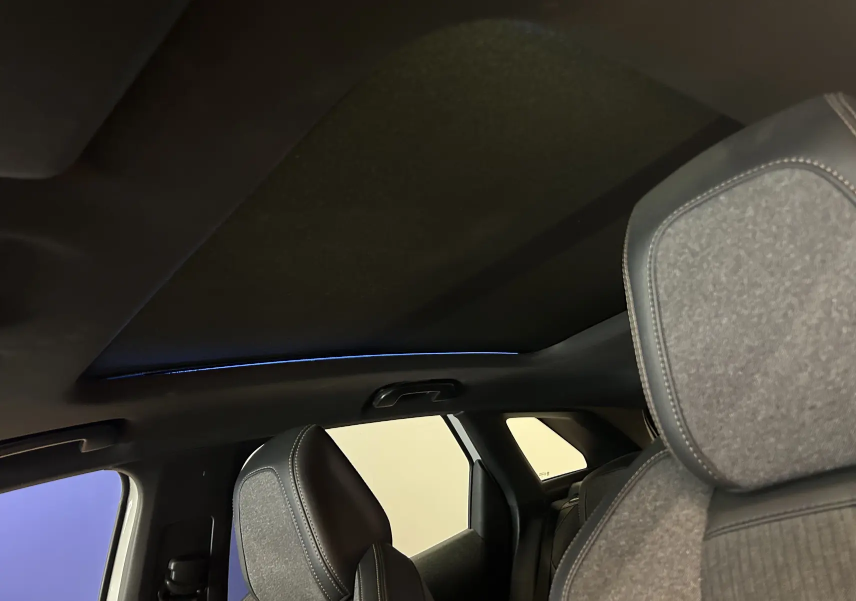 Vue intérieure du toit ouvrant et des sièges avant en tissu gris du Peugeot 3008 GT Line 2020.