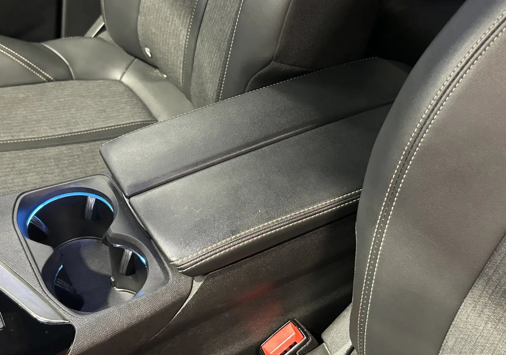 Gros plan sur l'accoudoir central noir et les porte-gobelets éclairés à LED à l'avant du Peugeot 3008 GT Line 2020.