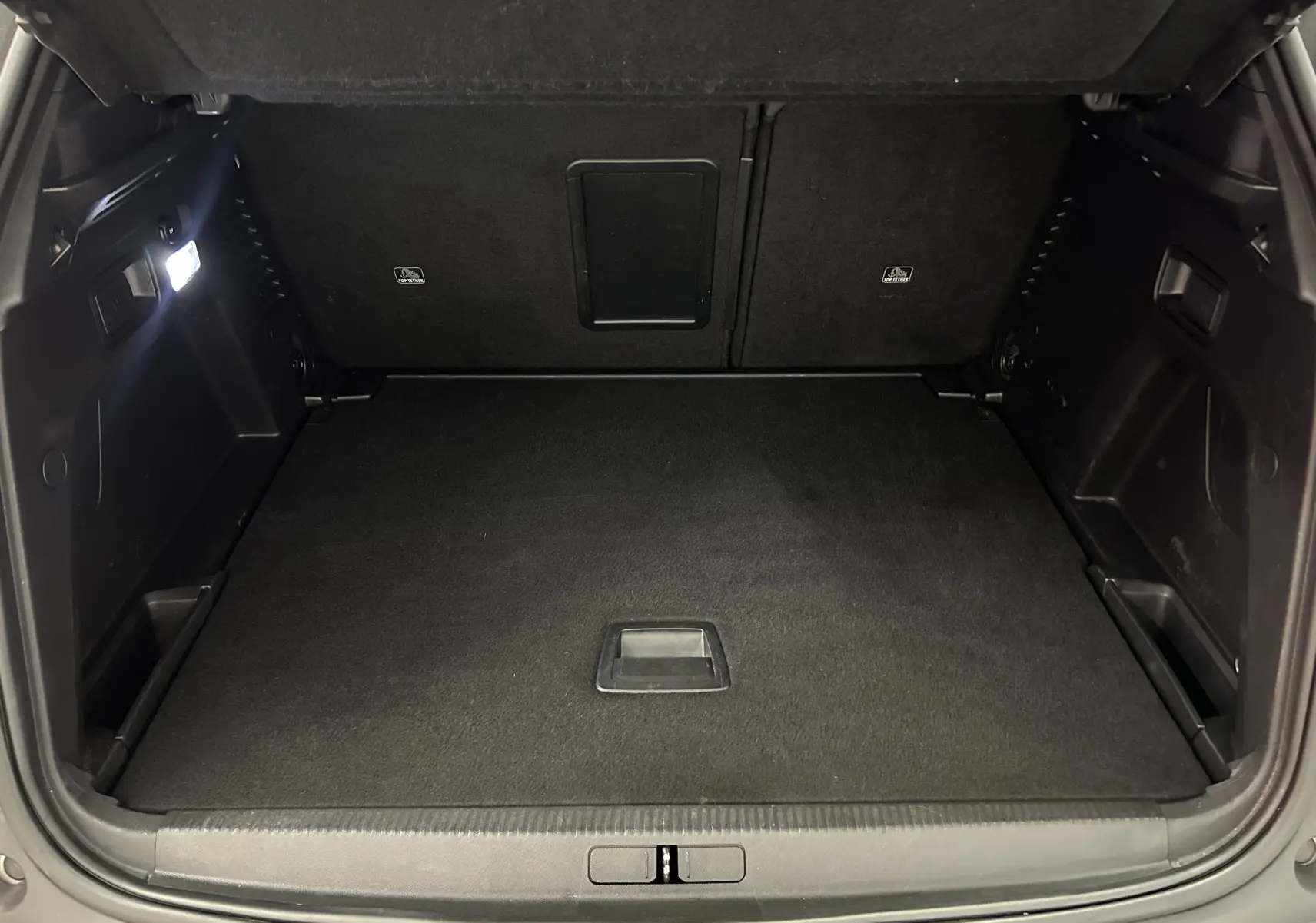 Coffre ouvert de Peugeot 3008 GT Line blanc, vue intérieure montrant un espace de chargement propre et bien éclairé.
