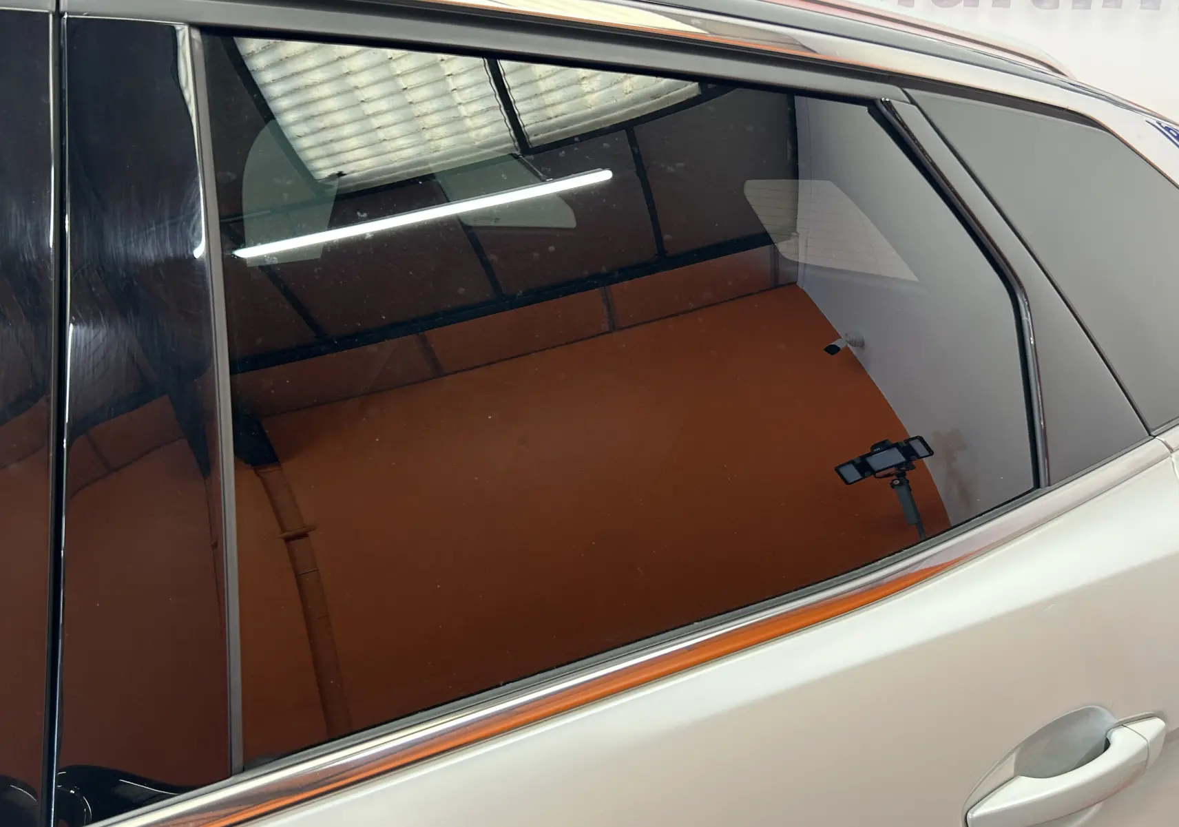 Gros plan sur la porte arrière droite blanche d’un Peugeot 3008 2020 avec vitres teintées et toit ouvrant visible.