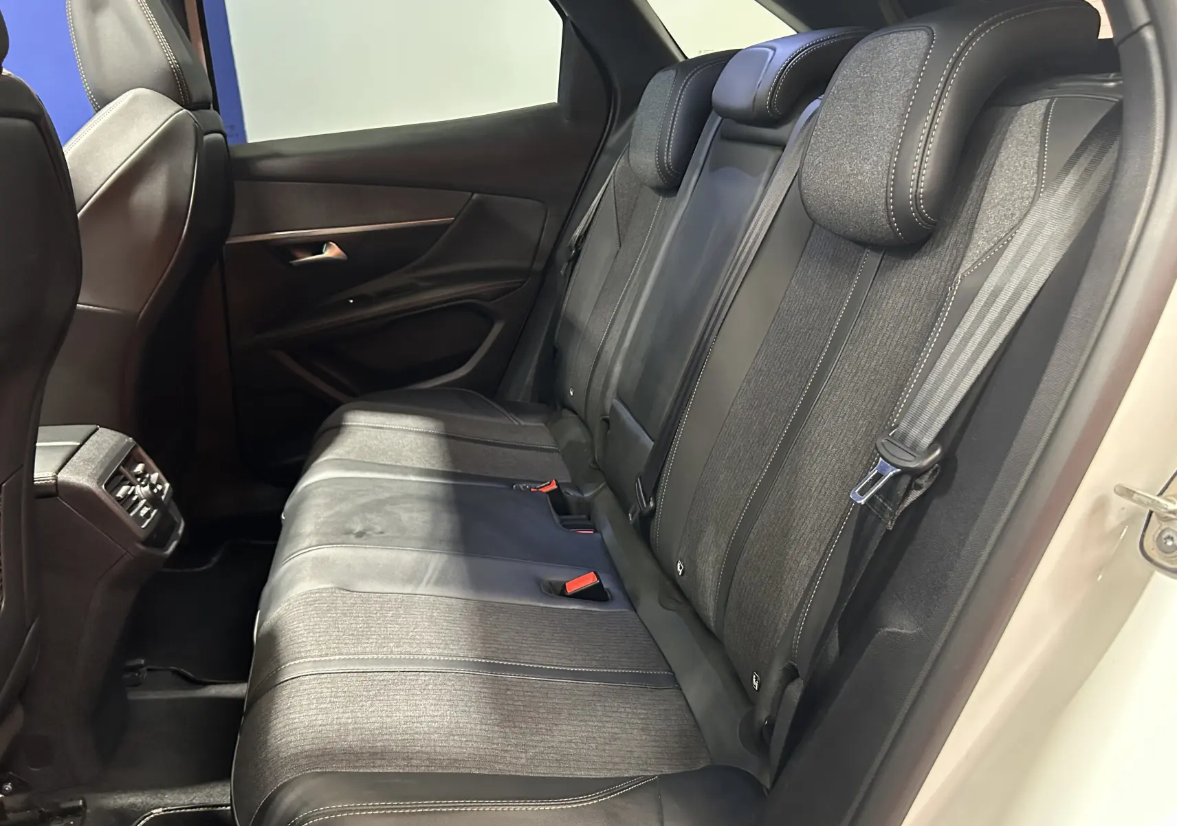 Vue intérieure côté droit des sièges arrière noirs et gris du Peugeot 3008 blanc, avec ceinture de sécurité visible.