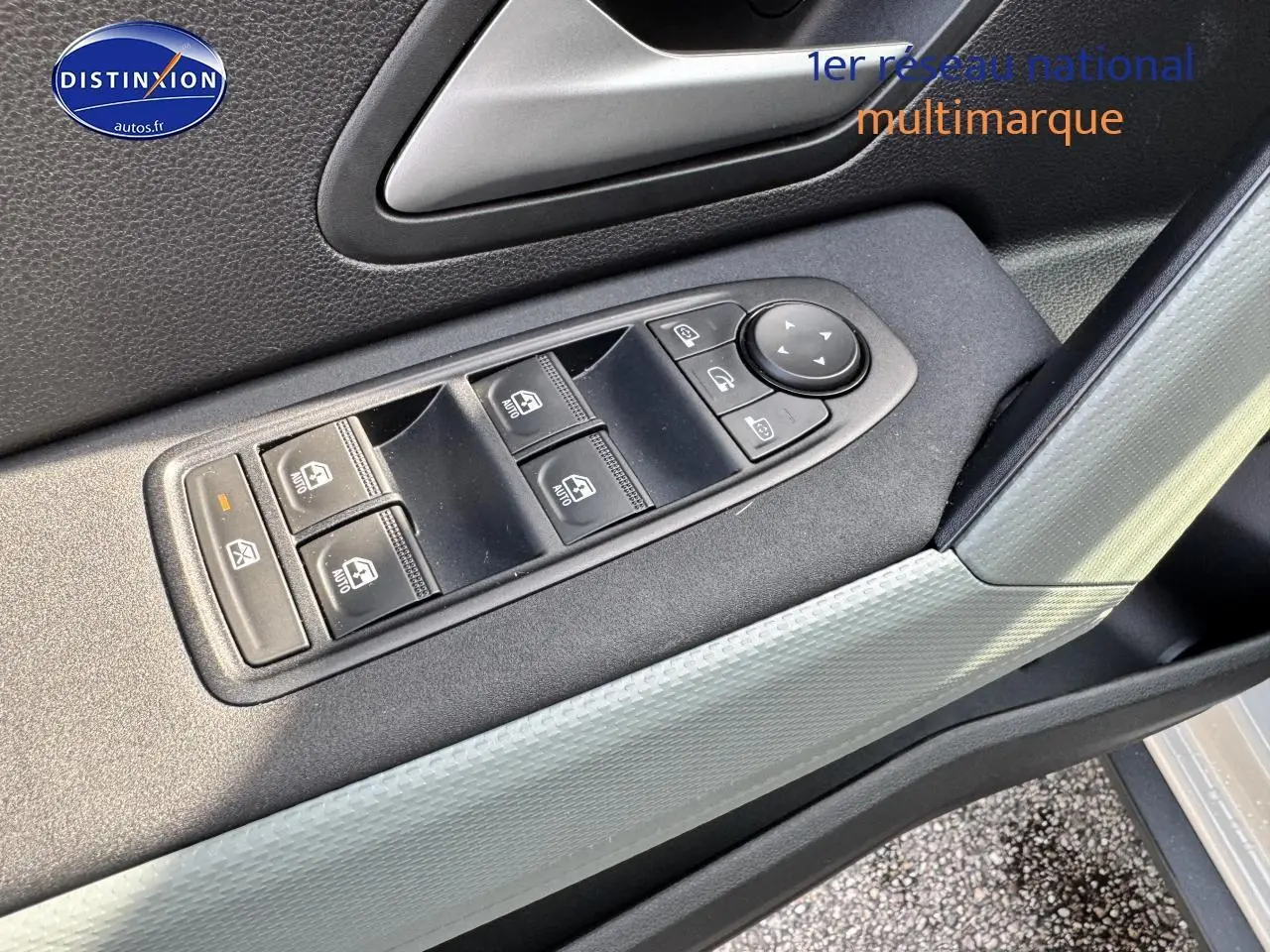 Détail des commandes des vitres électriques côté conducteur dans une Dacia Duster 2025 couleur Vert cèdre.