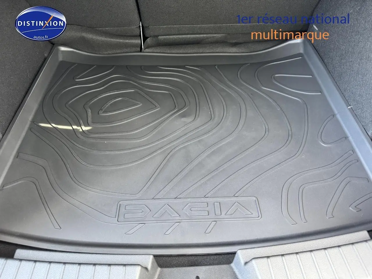 Vue plongeante sur le tapis de coffre noir avec logo Dacia du Duster 2025 vert cèdre